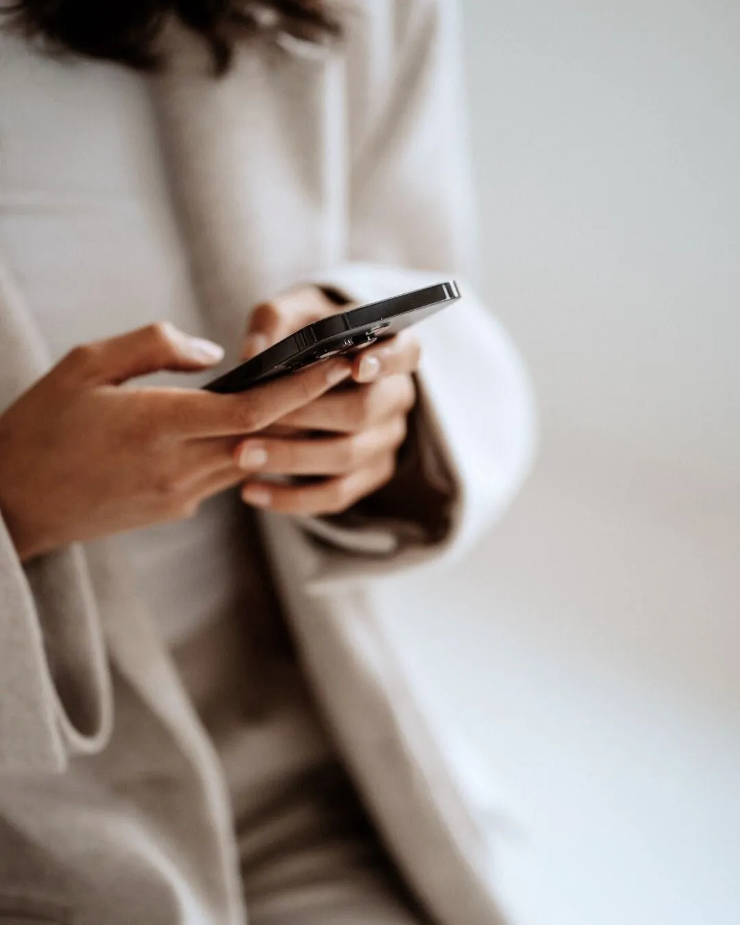 Mãos de mulher digitando em um celular